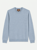 A light blue knit crewneck sweater with ribbed cuffs, hem, and collar, displayed flat against a light off-white background. A brown brand label reading 'GOBI' is visible inside the collar.
