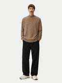 front view of a Person wearing a brown sweater and black pants on a white background #color_taupe