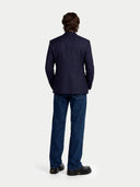 back view of a person wearing a navy suit and jeans on a white background #color_navy