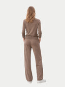 back view of a woman wearing a brown sweater and pants set on a white background #color_taupe