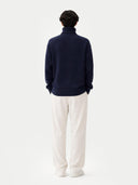 back view of a navy sweater and white pants on a white background #color_navy
