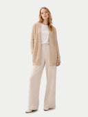 Woman wearing a beige cardigan, white top, and beige pants on a white background #color_beige