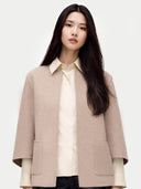 Woman wearing a beige open poncho over a white shirt on a white background #color_taupe