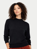 Woman wearing a black sweater against a plain background #color_black