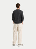 back view of a Person wearing a dark gray sweater and light beige pants on a white background #color_charcoal