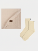 Beige blanket and socks set on a white background #color_beige