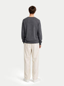 back view of a Person wearing a gray sweater and white pants on a light gray background #color_plum-kitten