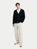 front view of a Man wearing a black cardigan, white shirt, and white pants on a white background #color_black