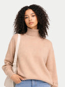 Woman wearing a beige turtleneck sweater against a white background #color_beige