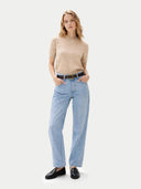 front view of a woman wearing a beige short-sleeve sweater and light blue jeans on a white background #color_beige