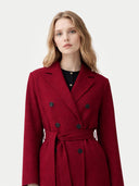 close up of a woman wearing a red coat with black buttons on a white background #color_bordeaux
