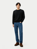 front view of a man wearing a black sweater and blue jeans on a white background #color_black
