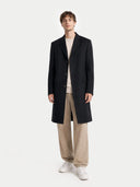 front view of a Man wearing a black coat, beige pants, and white shoes on a white background #color_black