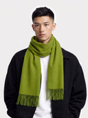 Model wearing the Cashmere Fringed Scarf in Green over a black jacket, close front view