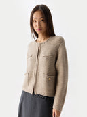 Woman wearing a beige knitted cardigan on a white background #color_warm-grey