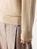 Close-up of a person wearing a beige sweater and pants on a white background #color_beige