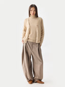 front view of a person wearing a beige v-neck cardigan over matching a sweater and pants on a white background #color_beige