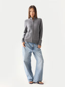 front view of a person wearing a gray zip-up hoodie and light blue jeans on a white background #color_dim-gray