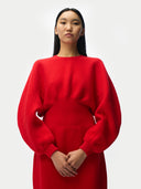 Close up of a person wearing a red sweater against a white background #color_fiery-red