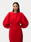 Close up of a person wearing a red outfit with puffed sleeves on a white background #color_fiery-red