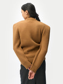 back view of person wearing a brown ribbed sweater on a white background #color_camel