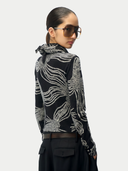 Person wearing a black and silver patterned jacket on a white background. #color_black