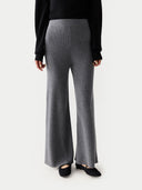Person wearing gray ribbed pants and a black top on a white background #color_dim-gray