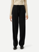 Person wearing black straight jogger with robe and a beige sweater on a white background #color_black