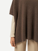 close up of a brown ribbed poncho over a white sweater and pants #color_cacao