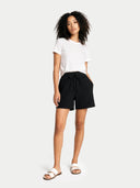 Woman wearing black shorts and a white t-shirt on a white background #color_black