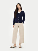front view of a Woman wearing a navy cardigan and beige pants on a white background #color_navy