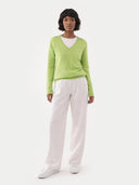 front view of Person wearing a green sweater and white pants on a white background #color_jade-lime