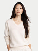 Woman wearing a light beige sweater against a white background #color_off-white