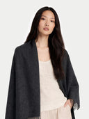 Woman wearing a dark gray blanket over a white top on a light gray background #color_charcoal