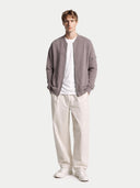 Man wearing a gray jacket, white shirt, and beige pants on a white background #color_stucco