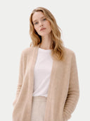 Woman wearing a beige cardigan over a white top on a light gray background #color_beige