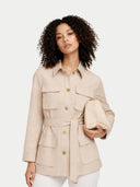 Woman wearing a beige jacket with button details on a white background #color_warm-grey