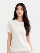 Woman wearing a white t-shirt against a plain background #color_whisper-white