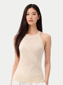 Woman wearing a beige sleeveless top against a white background #color_off-white