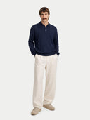 front view of a Man wearing a navy blue polo shirt and beige pants on a white background #color_navy