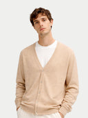 close up front view of a Man wearing a beige v-neck cardigan with pockets over a white shirt on a light gray background #color_beige