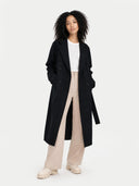 front view of a woman wearing a black coat, white shirt, and beige pants on a white background  #color_black