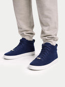 Navy high-top sneakers worn with gray pants on a white background #color_navy