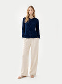 front view of a woman wearing a navy crew neck cardigan and beige pants on a white background #color_navy