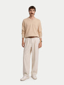 front view of a Man wearing a beige sweater and light-colored pants on a white background #color_beige