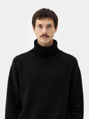 Man wearing a black turtleneck sweater against a white background #color_black