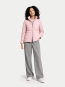 Person wearing a pink puffer jacket and gray pants on a white background #color_potpourri