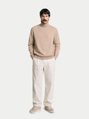 front view of a Man wearing a beige sweater and white pants on a plain background #color_beige