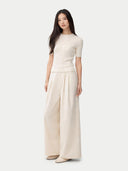 front view of a beige top and wide-leg pants on a white background #color_whisper-white