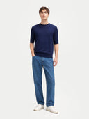 front view of man wearing a navy sweater and blue jeans on a white background #color_mood-indigo